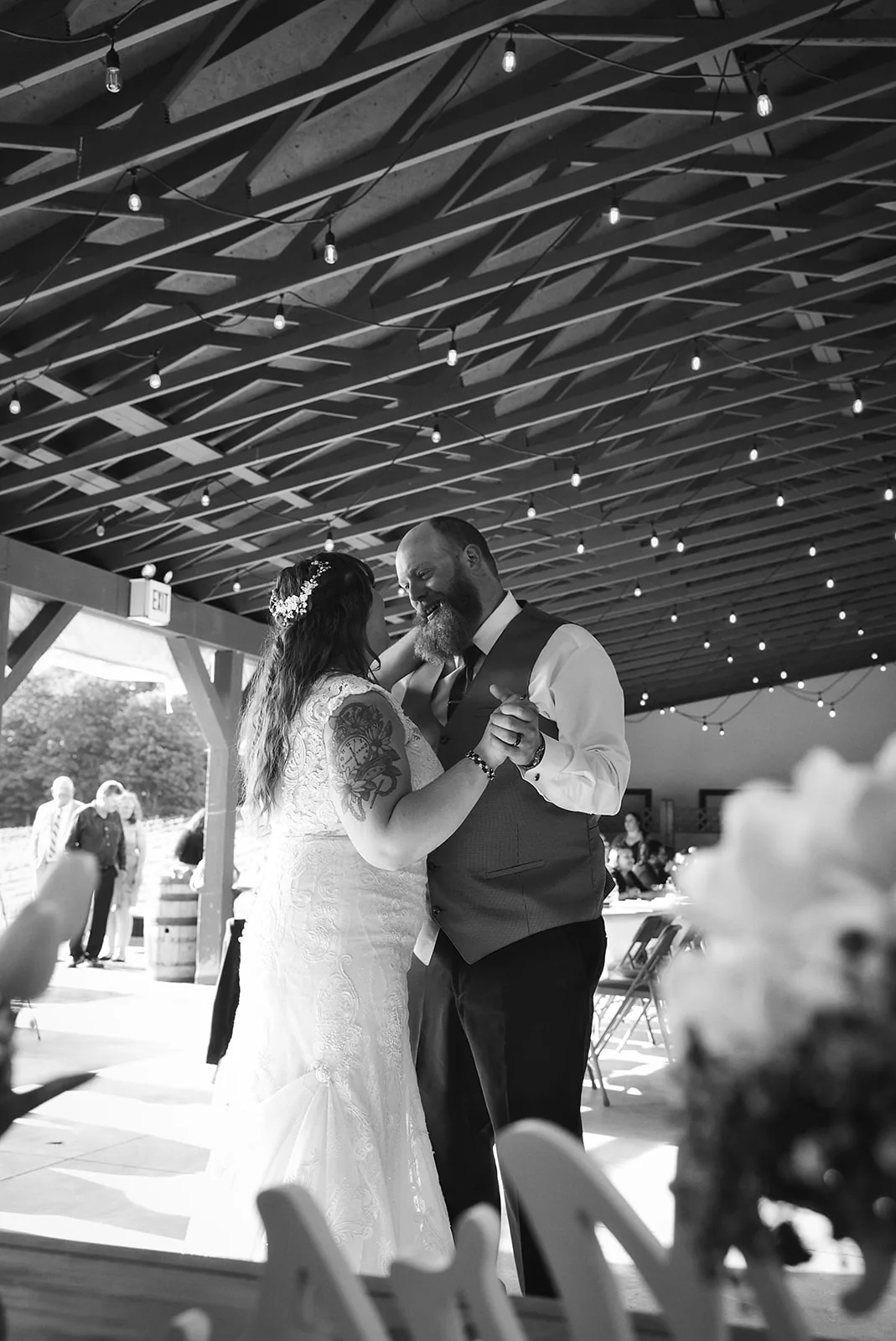 Bride and groom first dance at a vineyard reception, string lights overhead