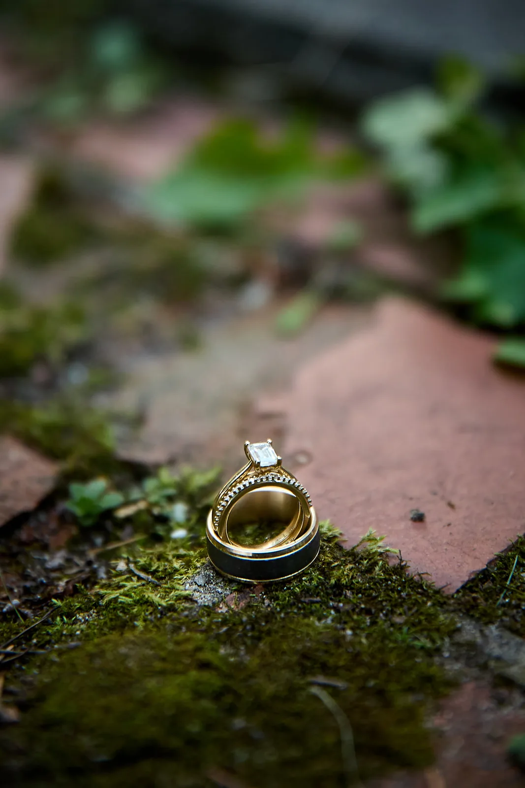 Macro detail of wedding rings resting on moss