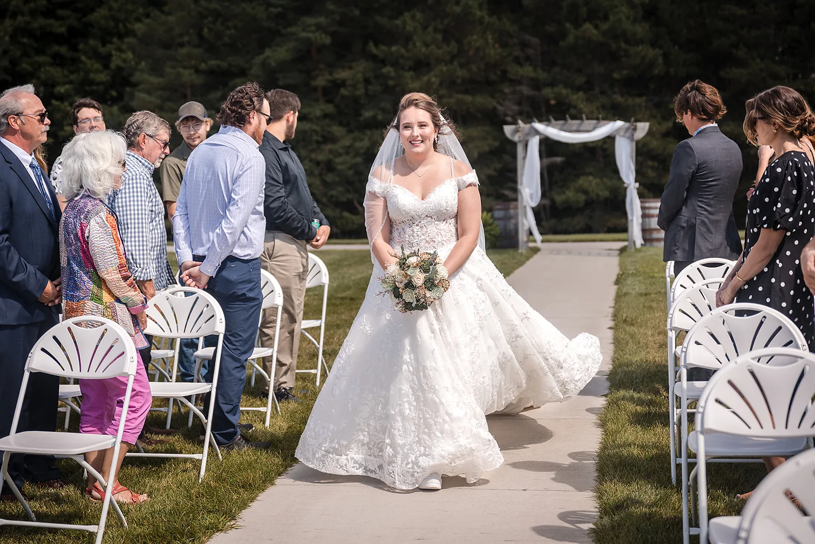 bride walking down aisle, guests seated on both sides