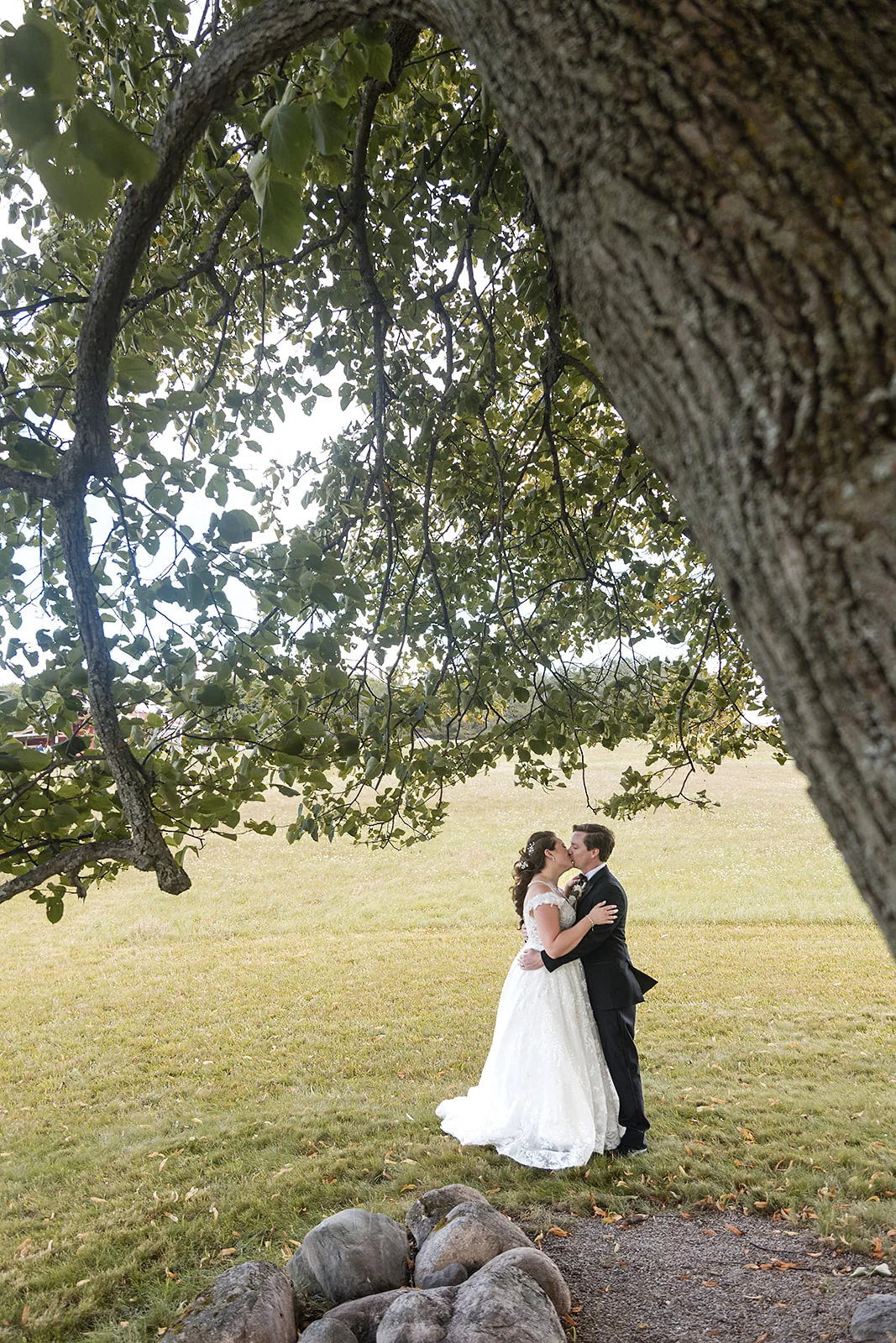 bride leading groom by hand through field, candid walking