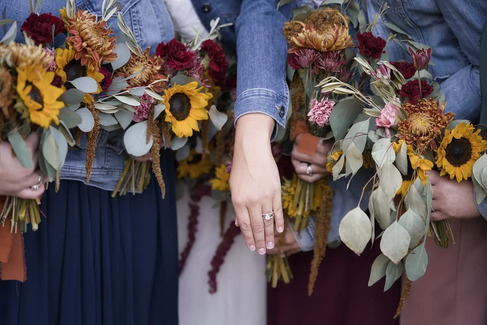 Close bridesmaids hands holding sunflower eucalyptus — Chelsea & Jake's wedding at Ogemaw County Fairgrounds, West Branch, MI