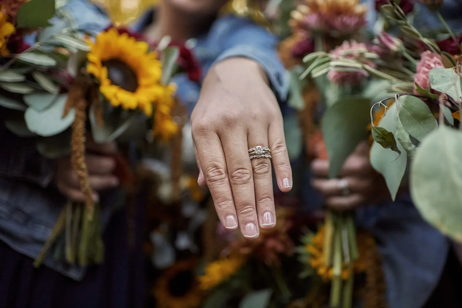 Close hands holding sunflower bouquets rings — Chelsea & Jake's wedding at Ogemaw County Fairgrounds, West Branch, MI