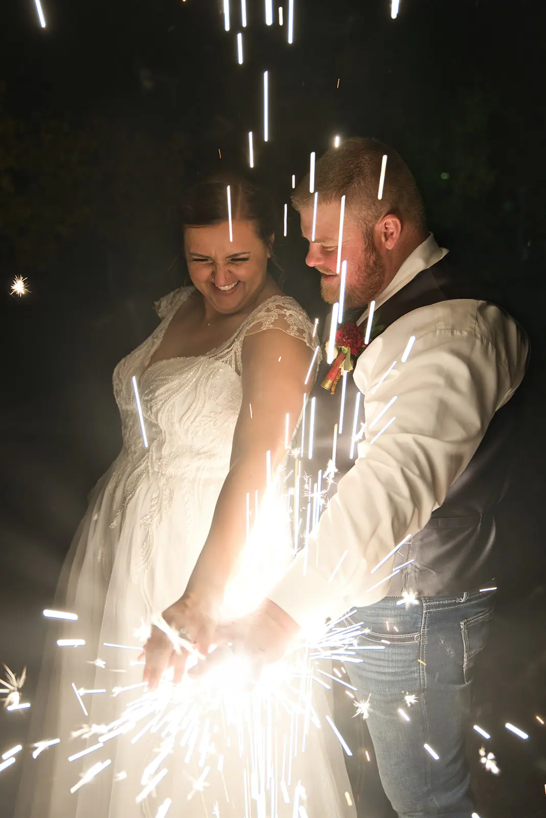 Couple laughing together inside shower sparklers — Chelsea & Jake's wedding at Ogemaw County Fairgrounds, West Branch, MI