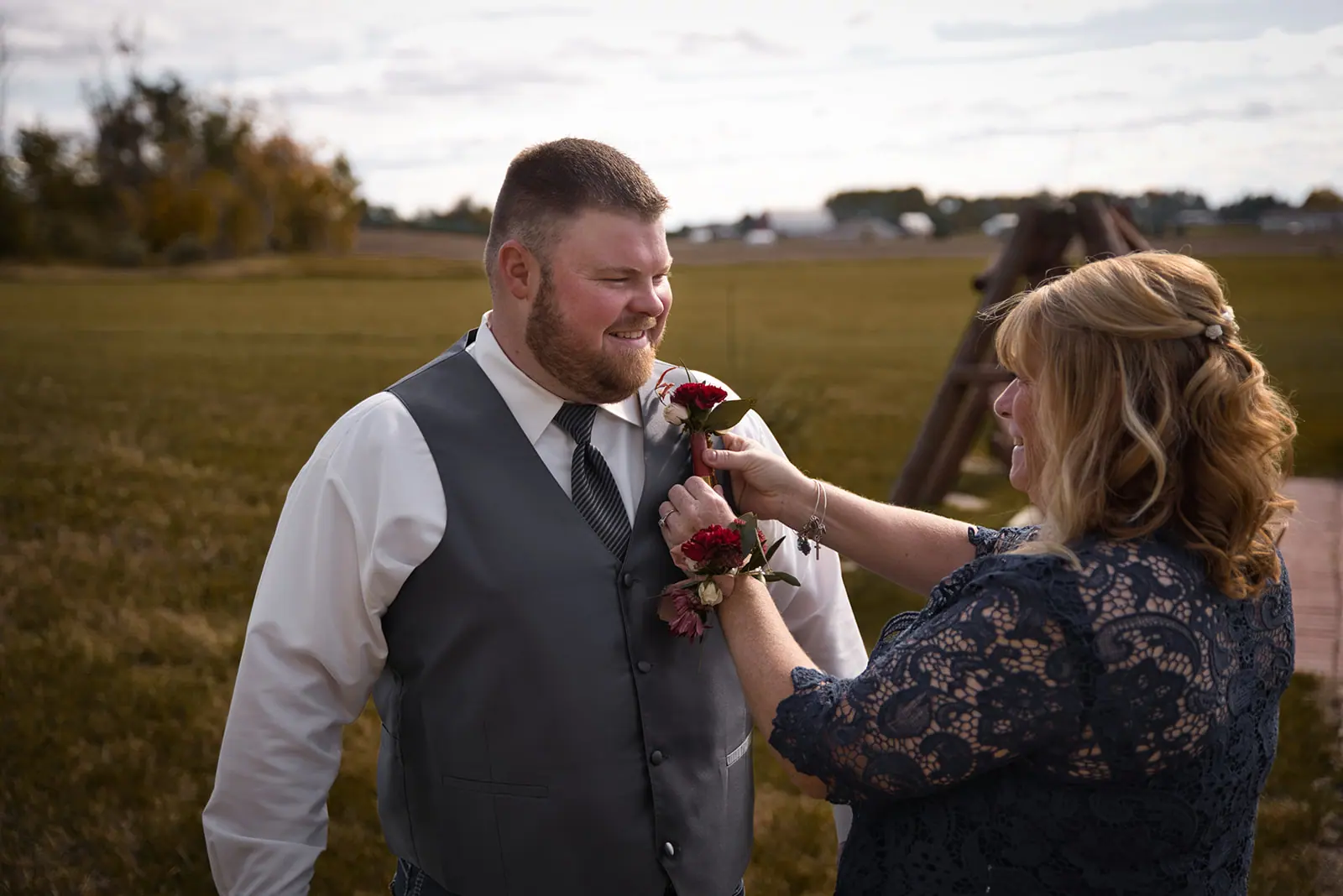 Groom grey vest outdoors woman lace — Chelsea & Jake's wedding at Ogemaw County Fairgrounds, West Branch, MI
