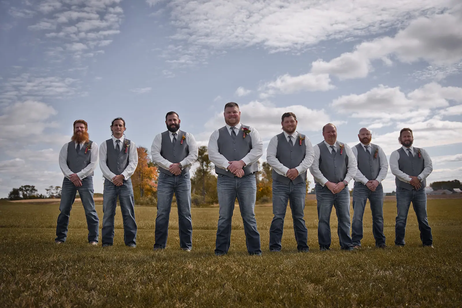 Groomsmen lined vests jeans open field — Chelsea & Jake's wedding at Ogemaw County Fairgrounds, West Branch, MI