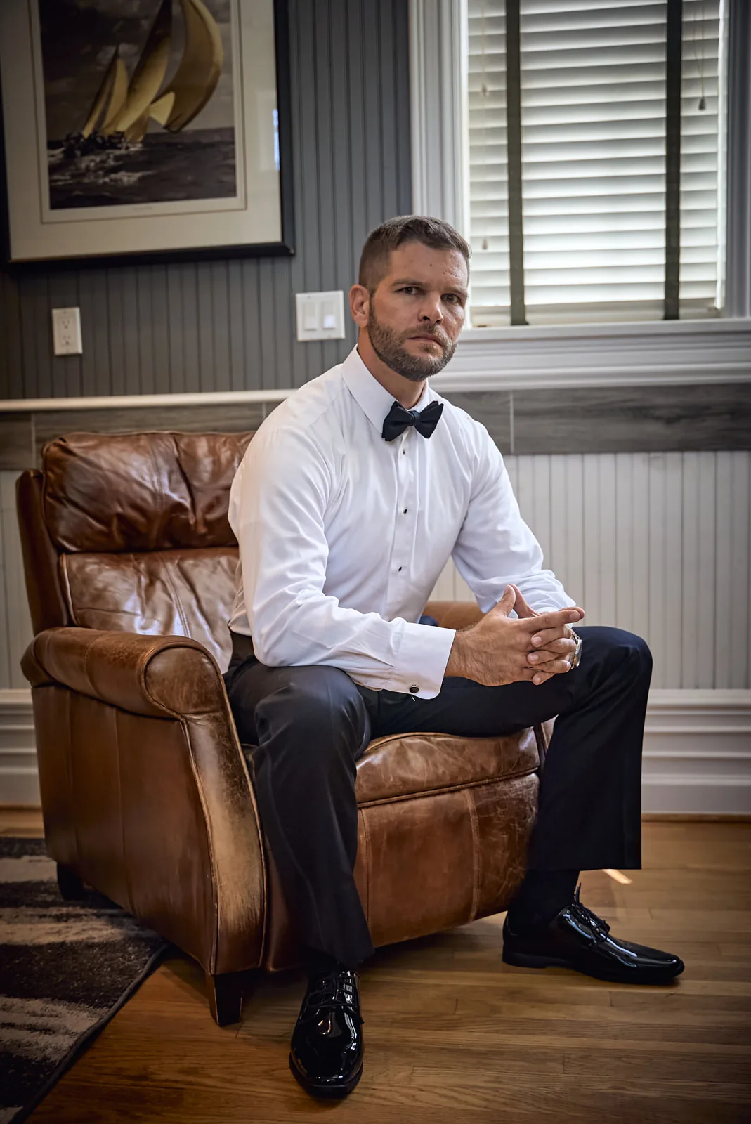 groom getting ready, looking out window buttoning cuff