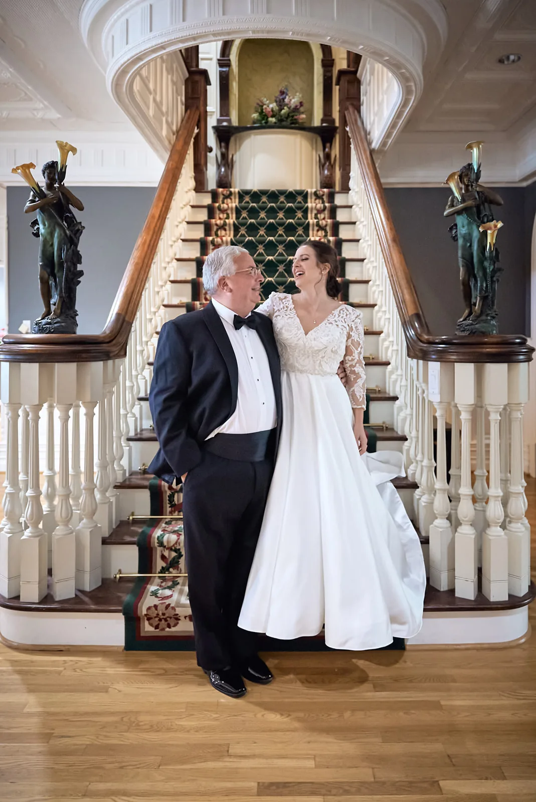 bride descending grand staircase at mansion venue, father watching