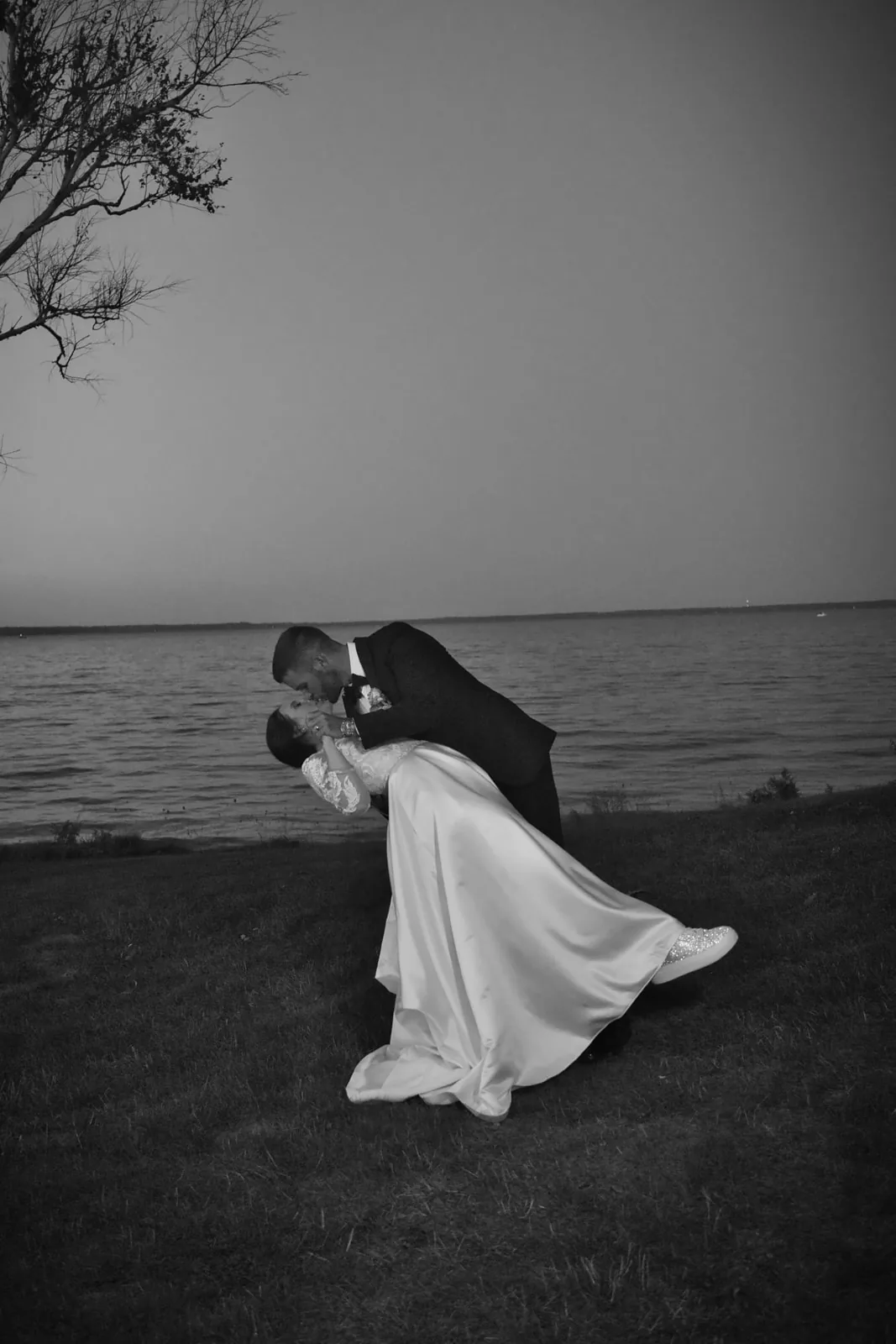bw couple dip kiss silhouette by water at dusk