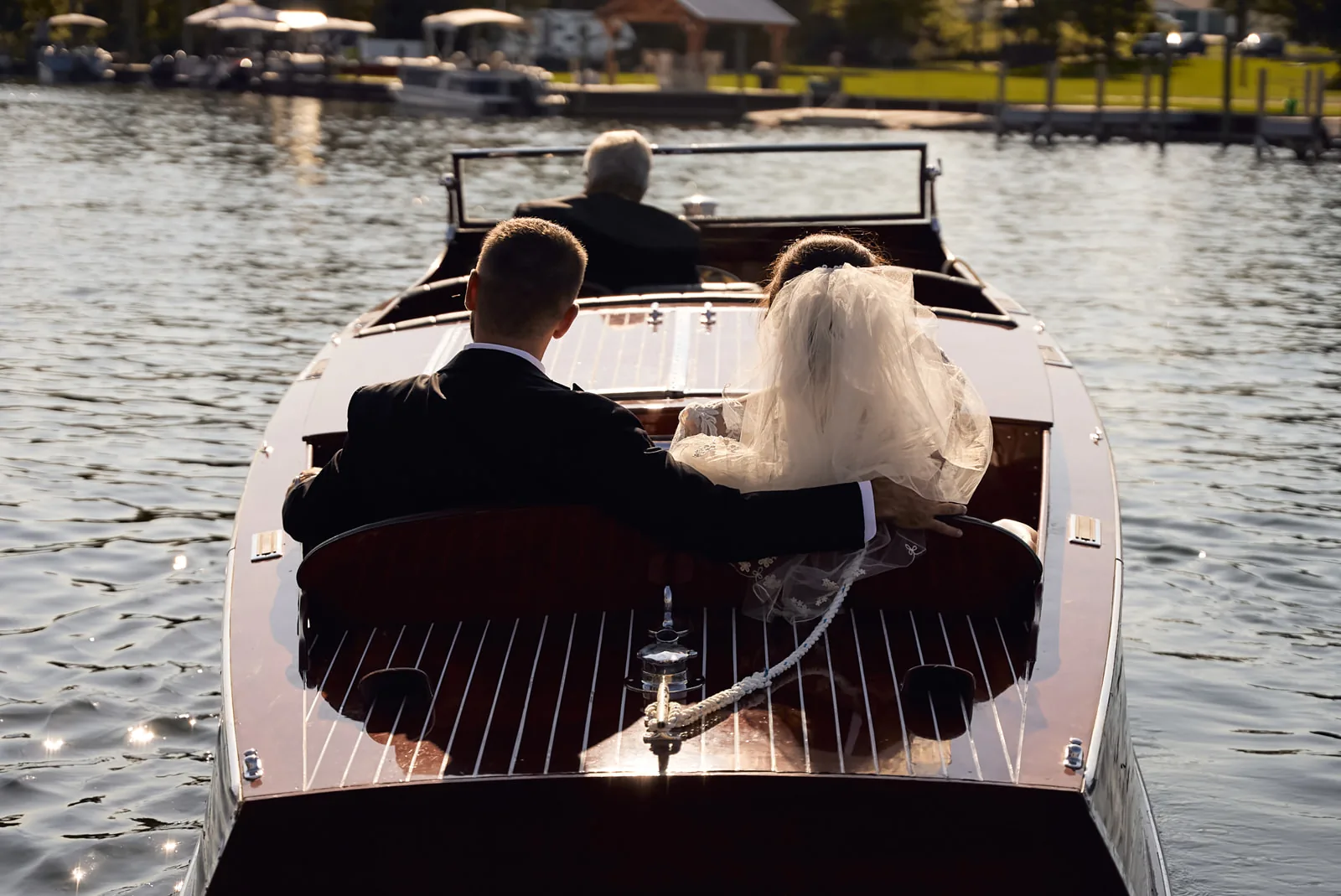 wide shot from behind of couple riding small boat on water