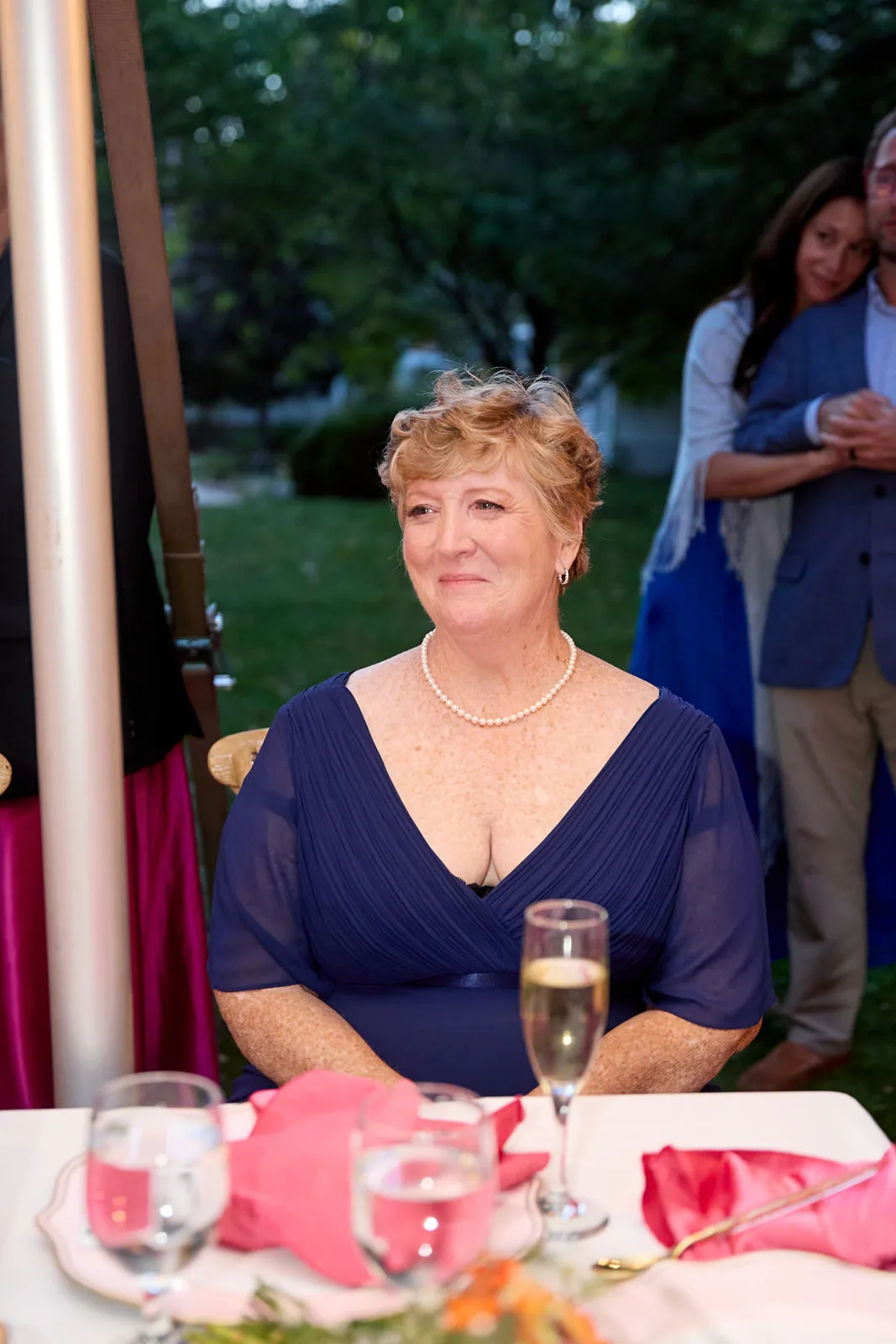 female guest seated at reception table smiling, candid portrait