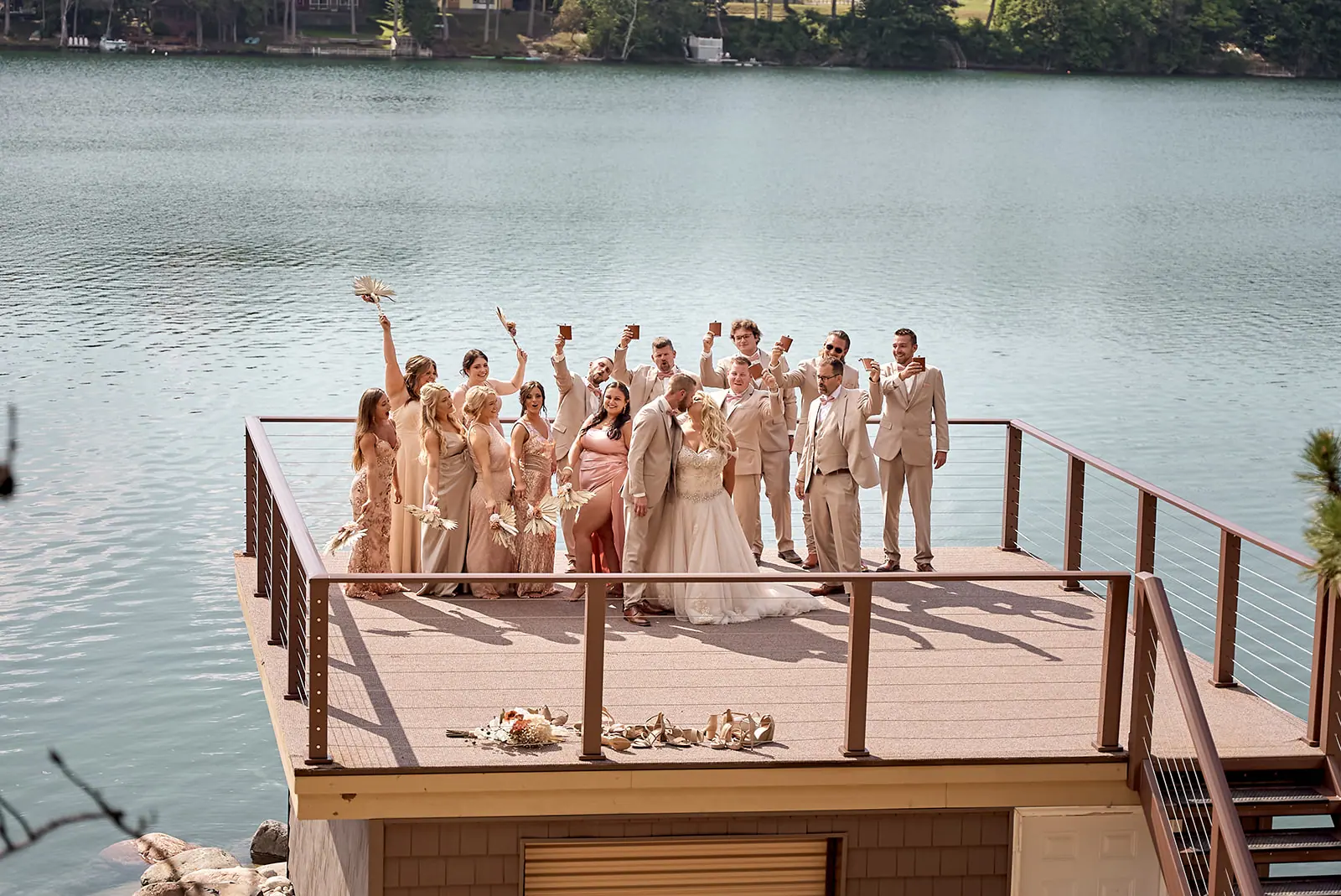 Bridal party cheering lakeside deck — Erika & Corey's wedding at Sojourn Lakeside Resort, Gaylord, MI