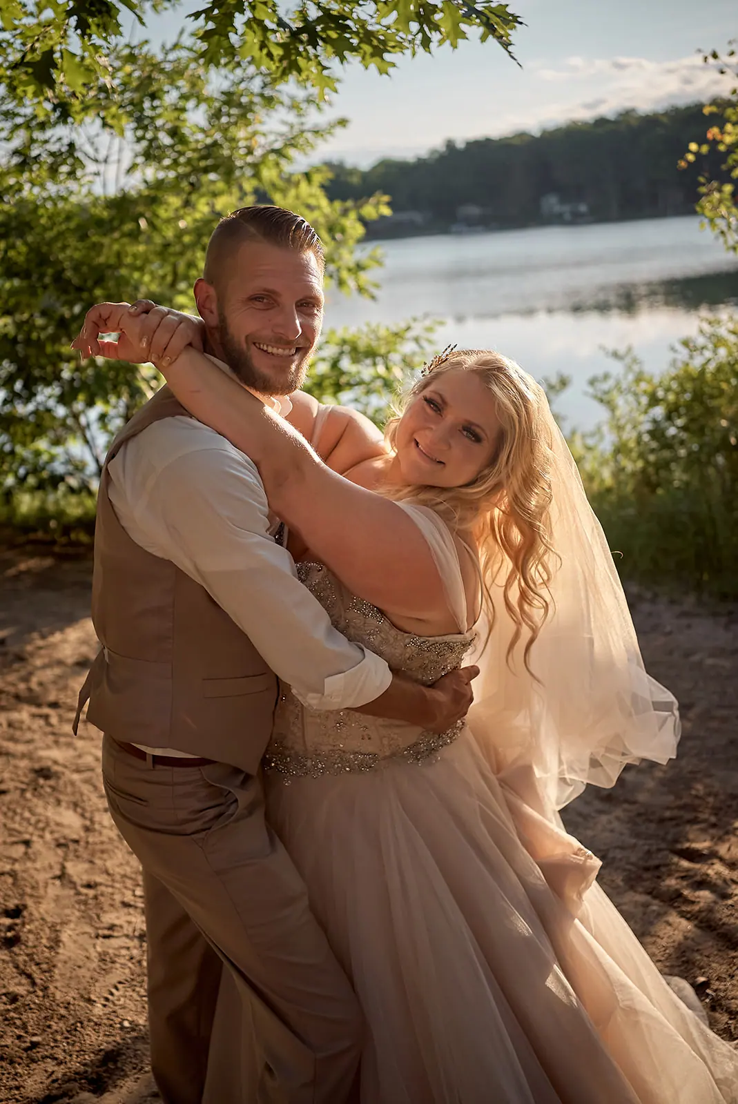 Couple embracing veil around them lake — Erika & Corey's wedding at Sojourn Lakeside Resort, Gaylord, MI