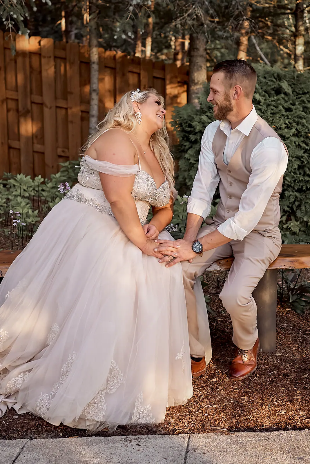 Couple holding hands seated garden bench — Erika & Corey's wedding at Sojourn Lakeside Resort, Gaylord, MI