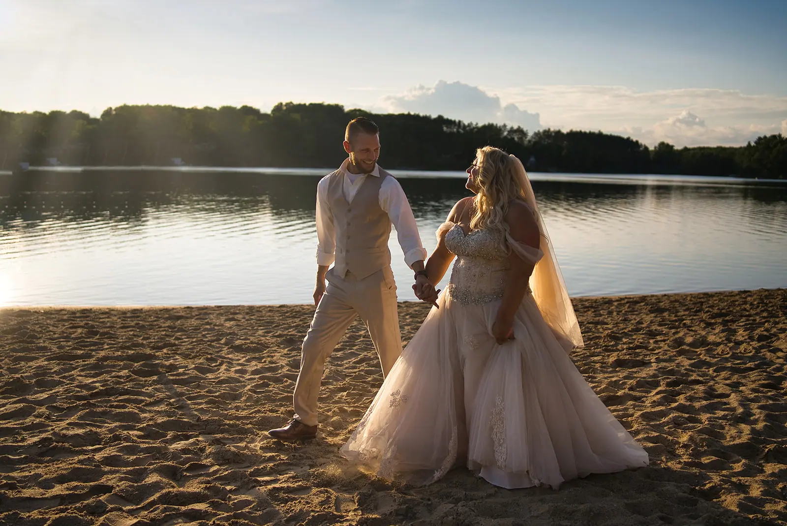 Couple walking along sandy shore sunset — Erika & Corey's wedding at Sojourn Lakeside Resort, Gaylord, MI