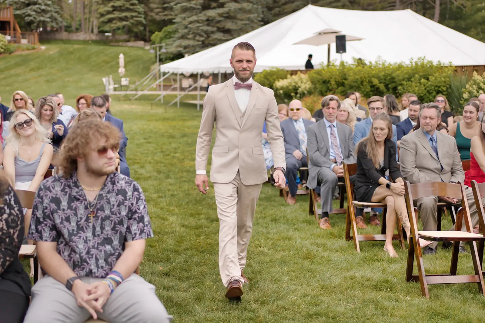 Groom tan suit bow tie walking — Erika & Corey's wedding at Sojourn Lakeside Resort, Gaylord, MI