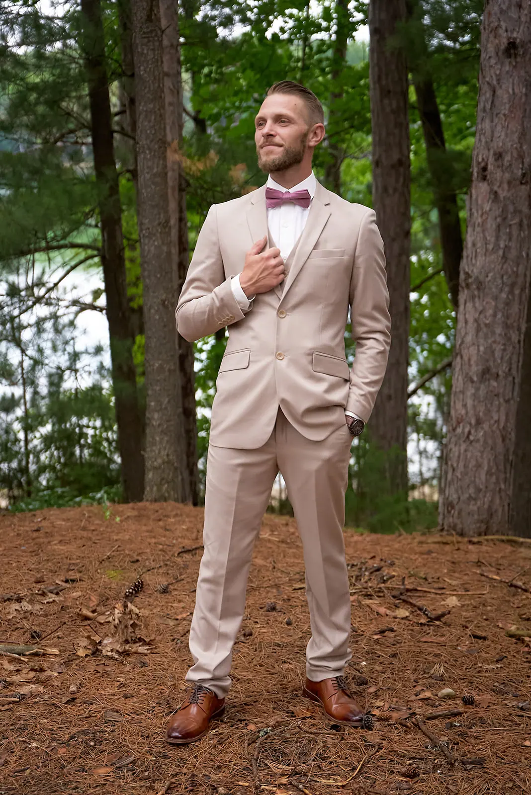 Groom tan suit pink tie standing — Erika & Corey's wedding at Sojourn Lakeside Resort, Gaylord, MI
