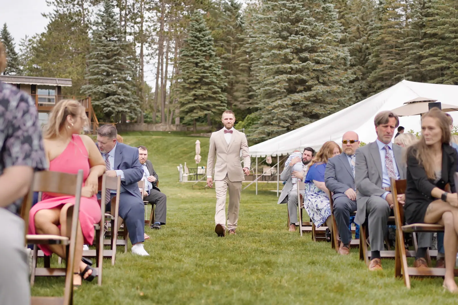 Groom walking aisle past seated guests — Erika & Corey's wedding at Sojourn Lakeside Resort, Gaylord, MI