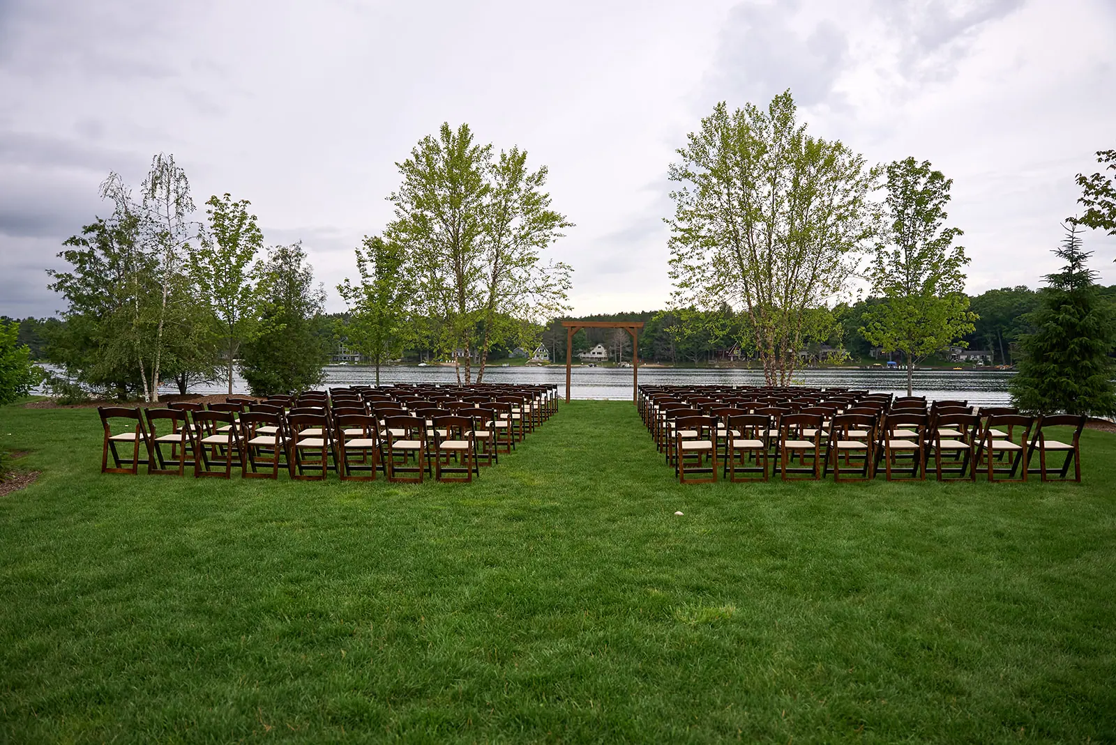 Rows chairs lawn facing lake trees — Erika & Corey's wedding at Sojourn Lakeside Resort, Gaylord, MI