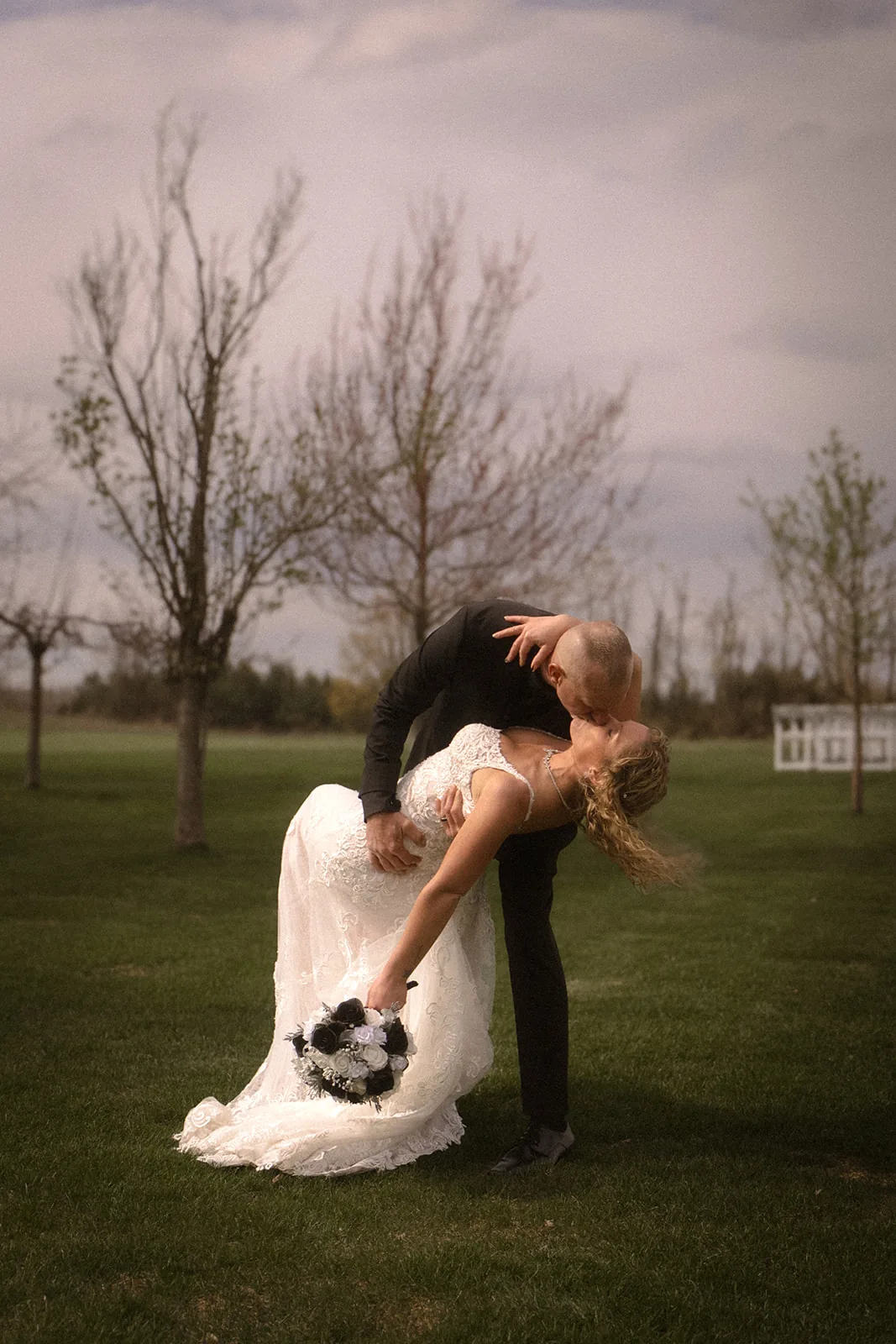 bride and groom embracing forehead to forehead, barn backdrop