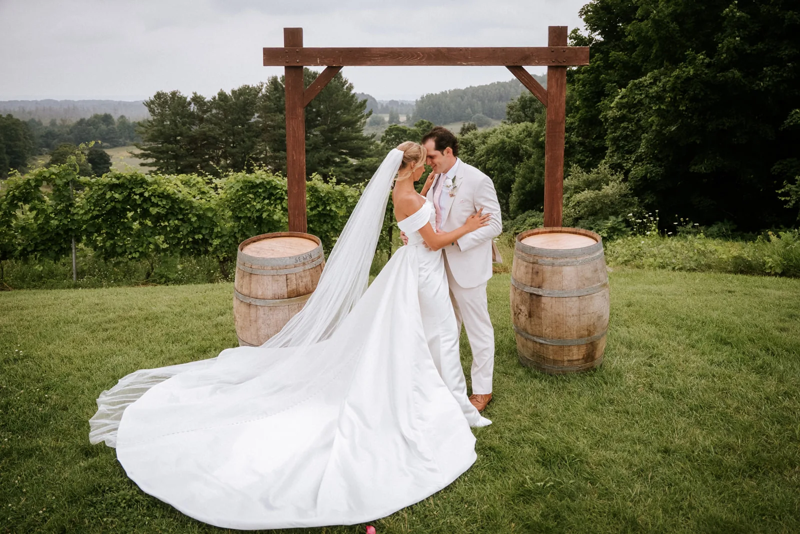 couple portrait with dog Loui in vineyard, wine barrels