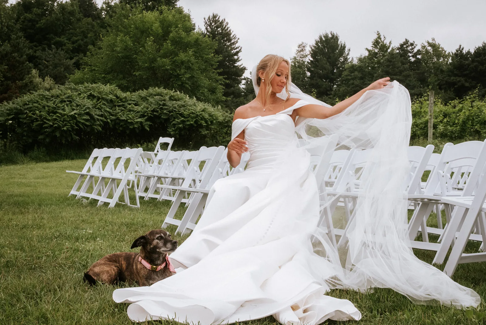 bw bride with long veil flowing in front of mansion columns