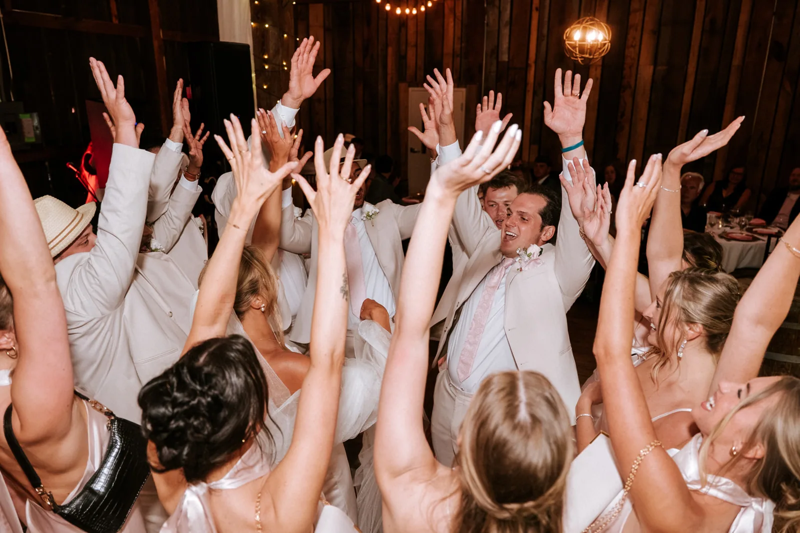 reception candid guests hands raised dancing, different angle