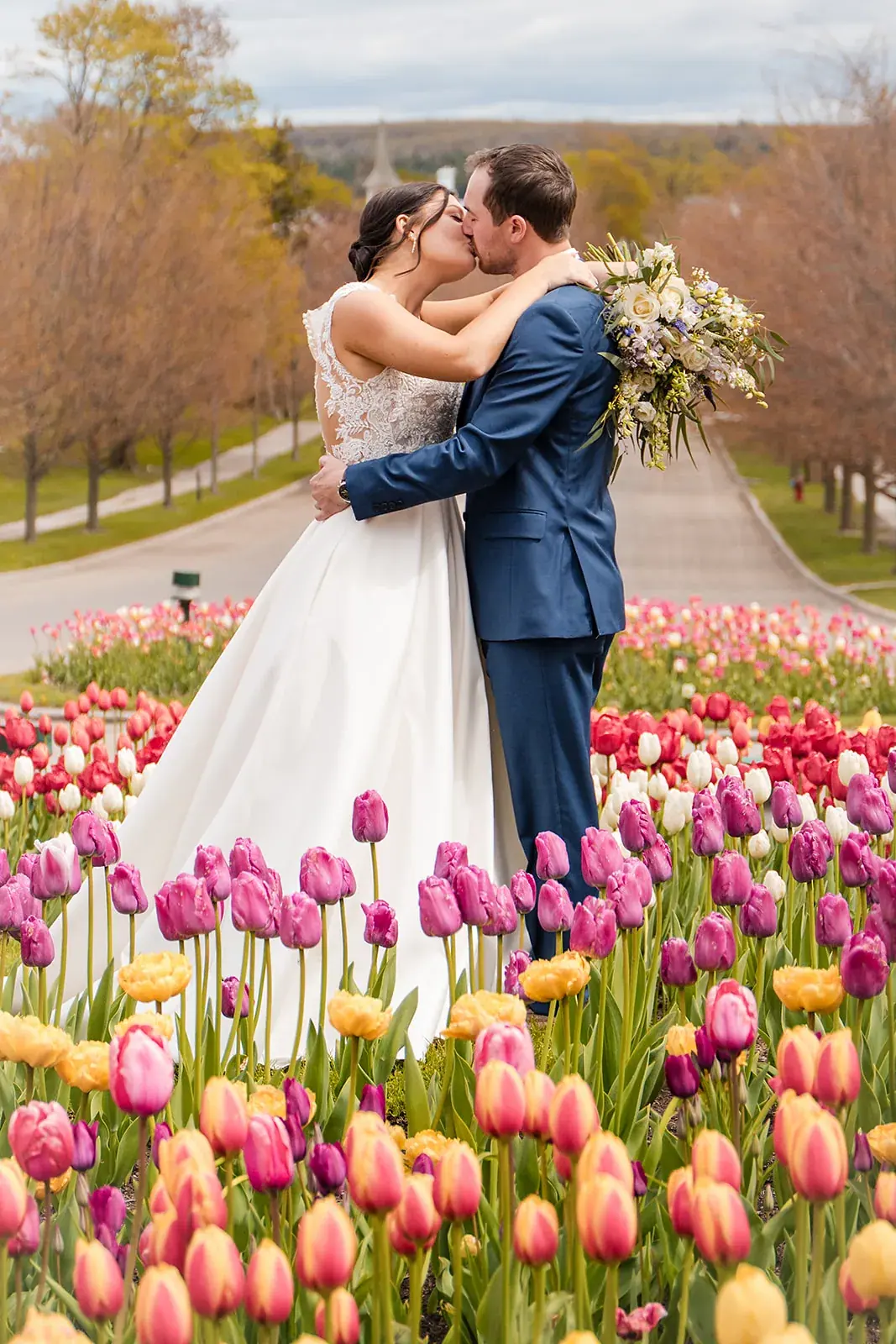 Bride and groom kiss tulip path — Jennifer & Parker's wedding at the Grand Hotel, Mackinac Island