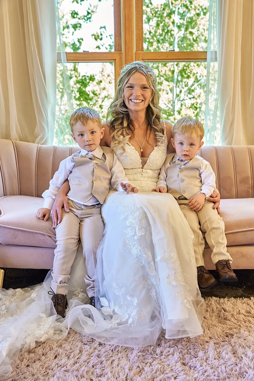 bride sitting with two ring bearer boys on couch, getting ready