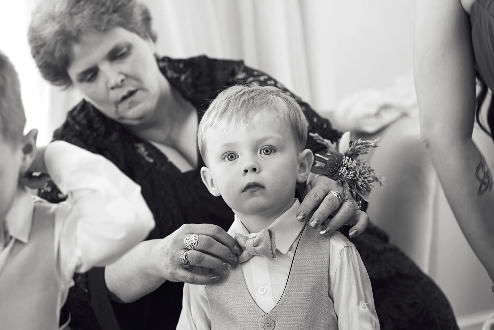 bw grandmother adjusting ring bearer boutonniere, candid