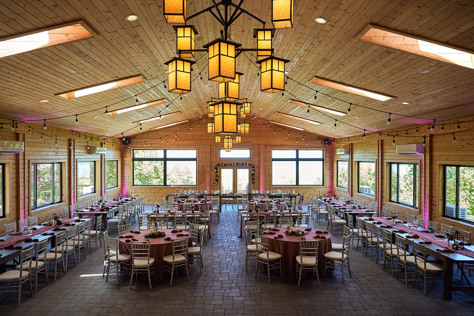 wide shot bride and groom kissing under pavilion with wine barrels