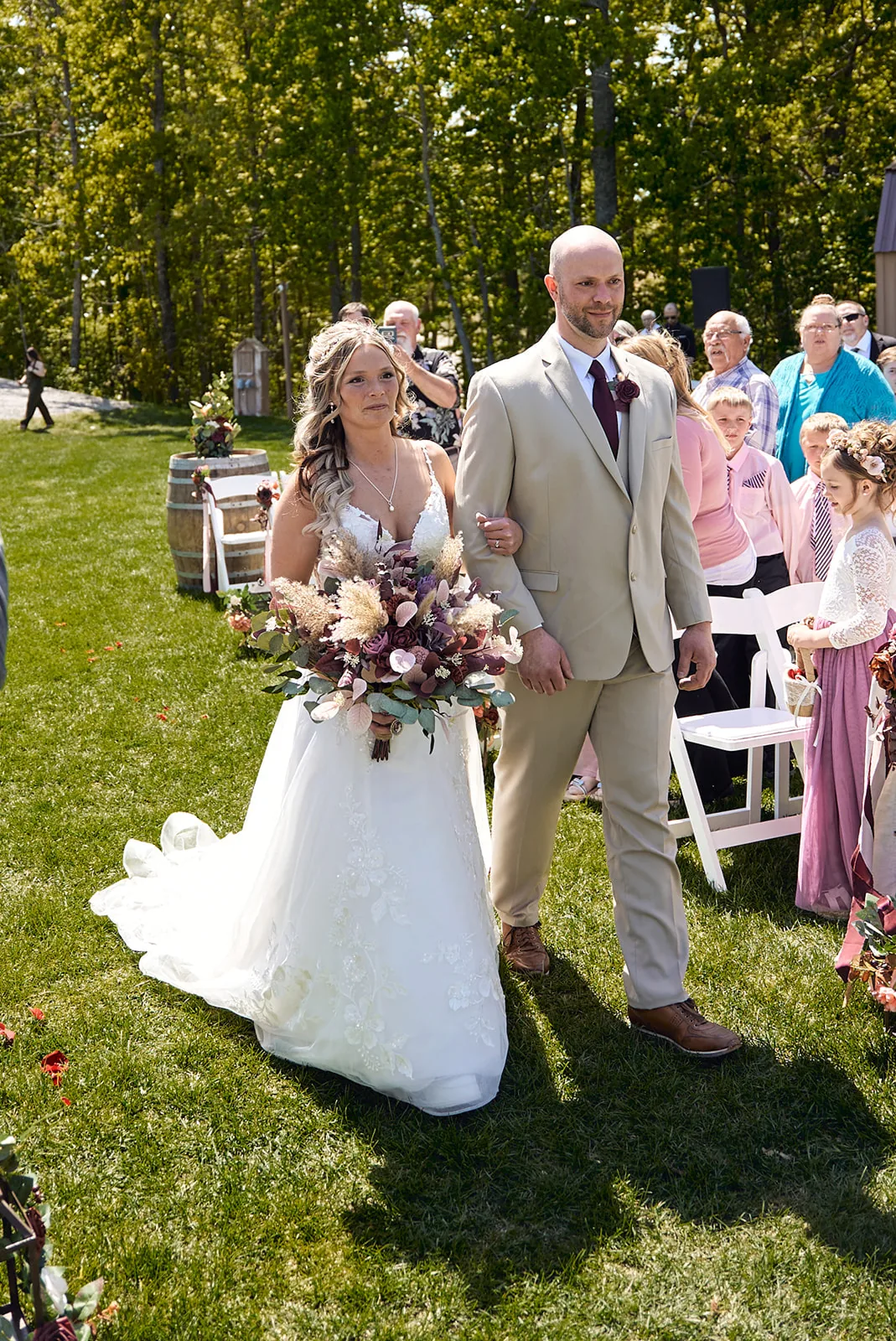flower girls walking down aisle at outdoor ceremony, wide shot