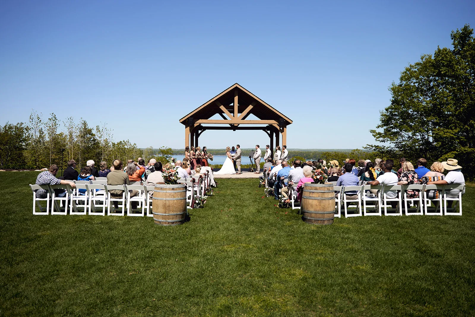 officiant and groomsmen standing at wooden pavilion altar