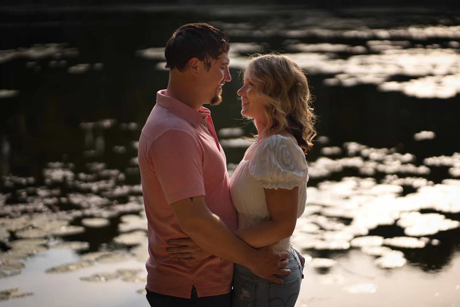 couple nose to nose portrait by pond at dusk
