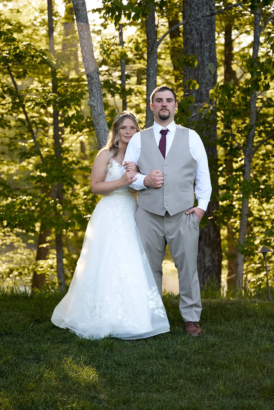 bride and groom standing portrait in forest clearing, golden light