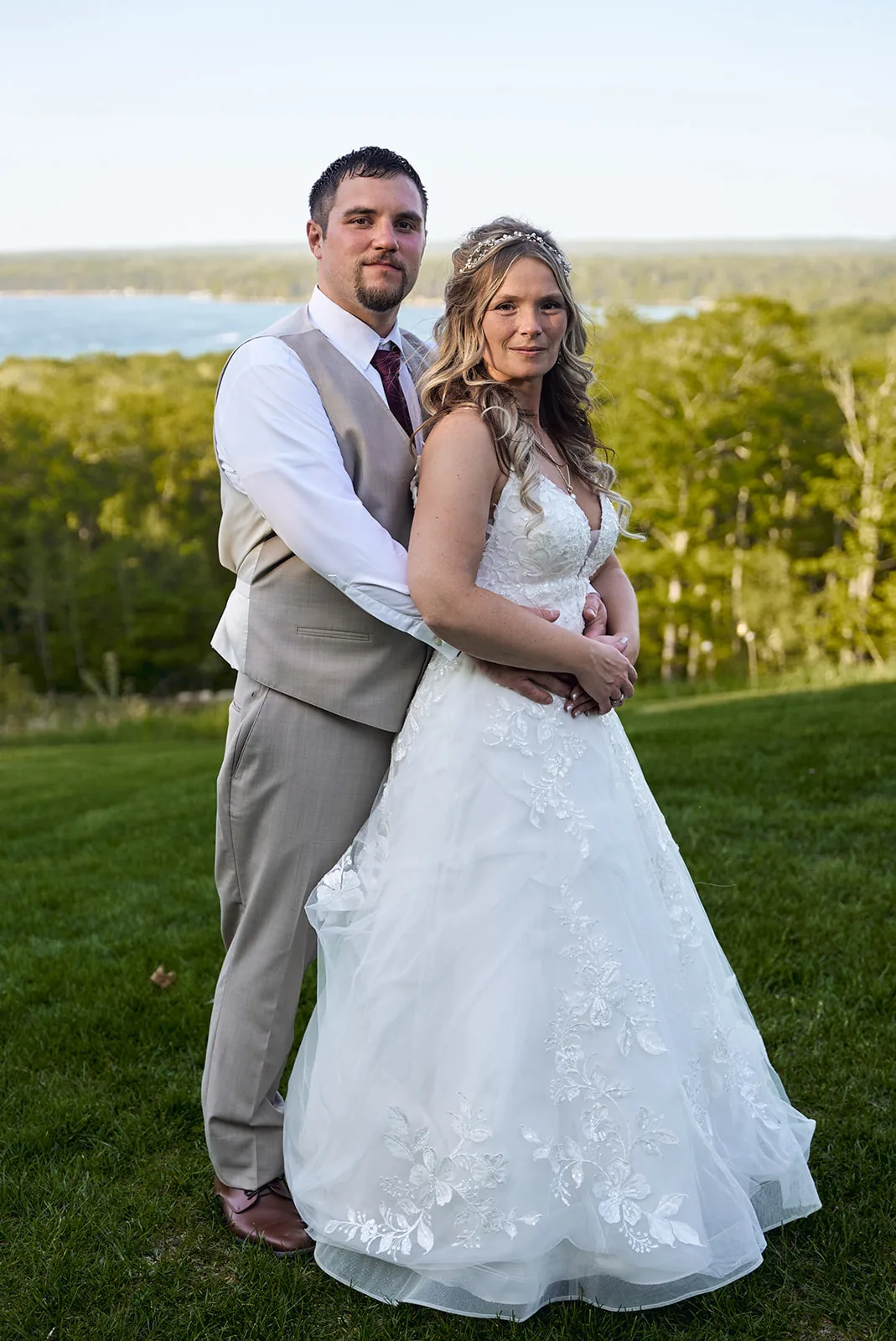 bride and groom portrait with lake visible behind trees