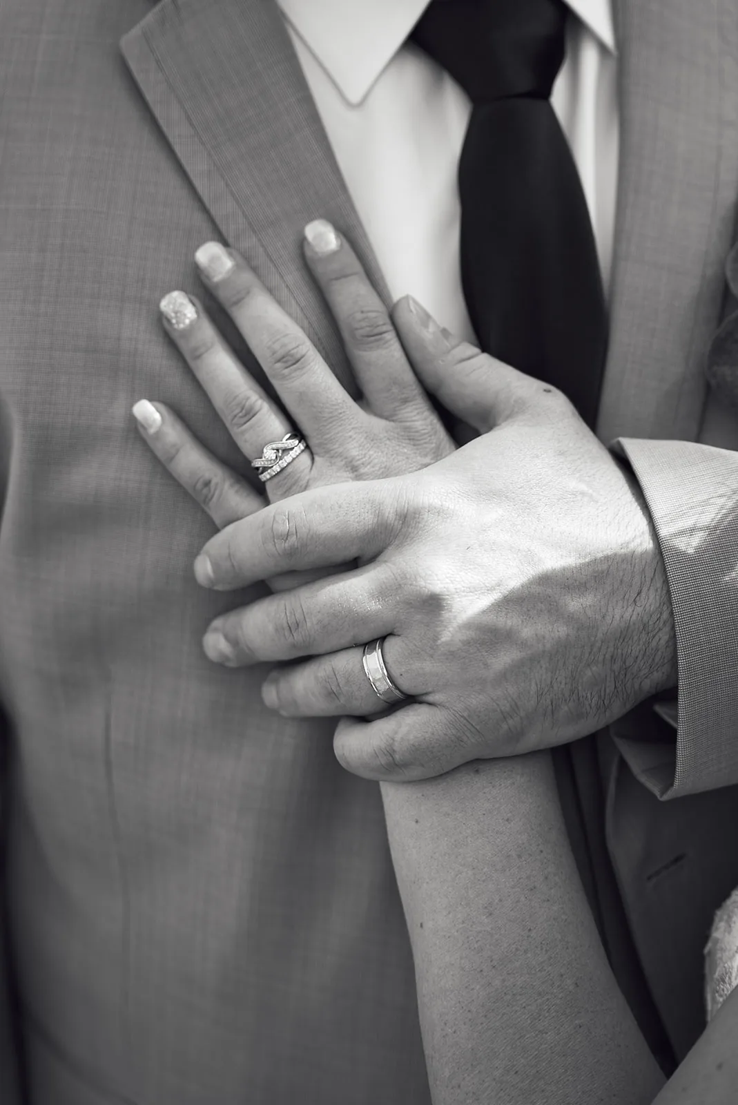 bride and groom walking across lawn toward camera, smiling, lake view
