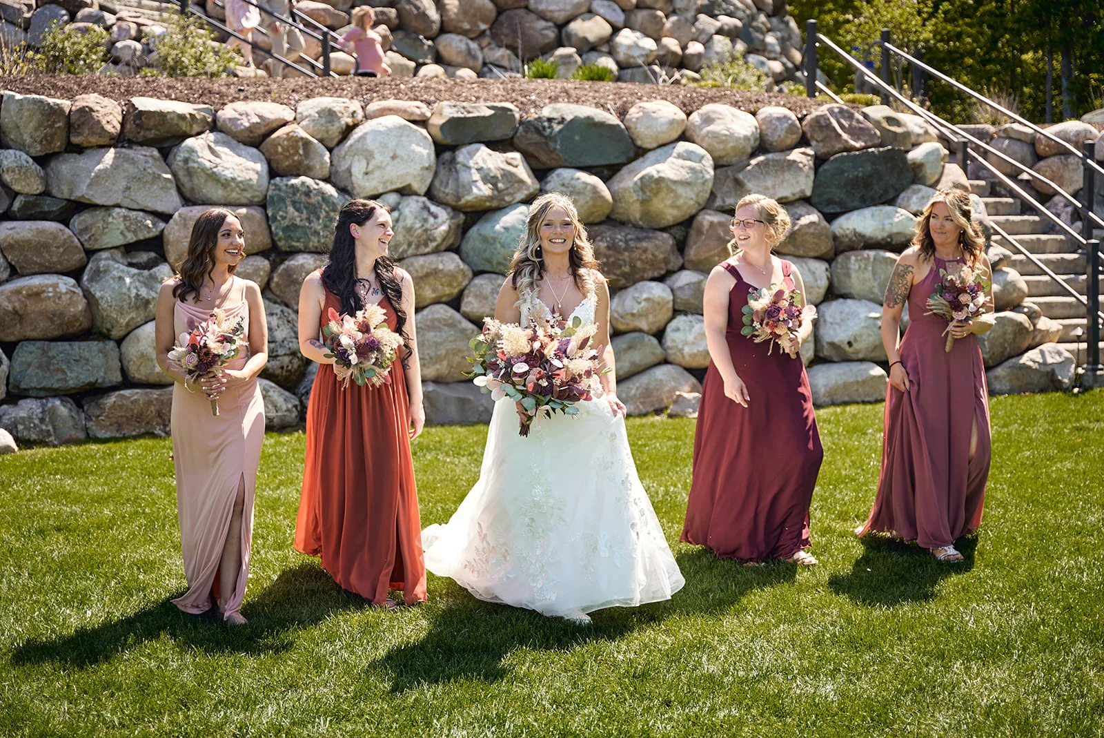 bridesmaids group portrait with bouquets, stone wall backdrop