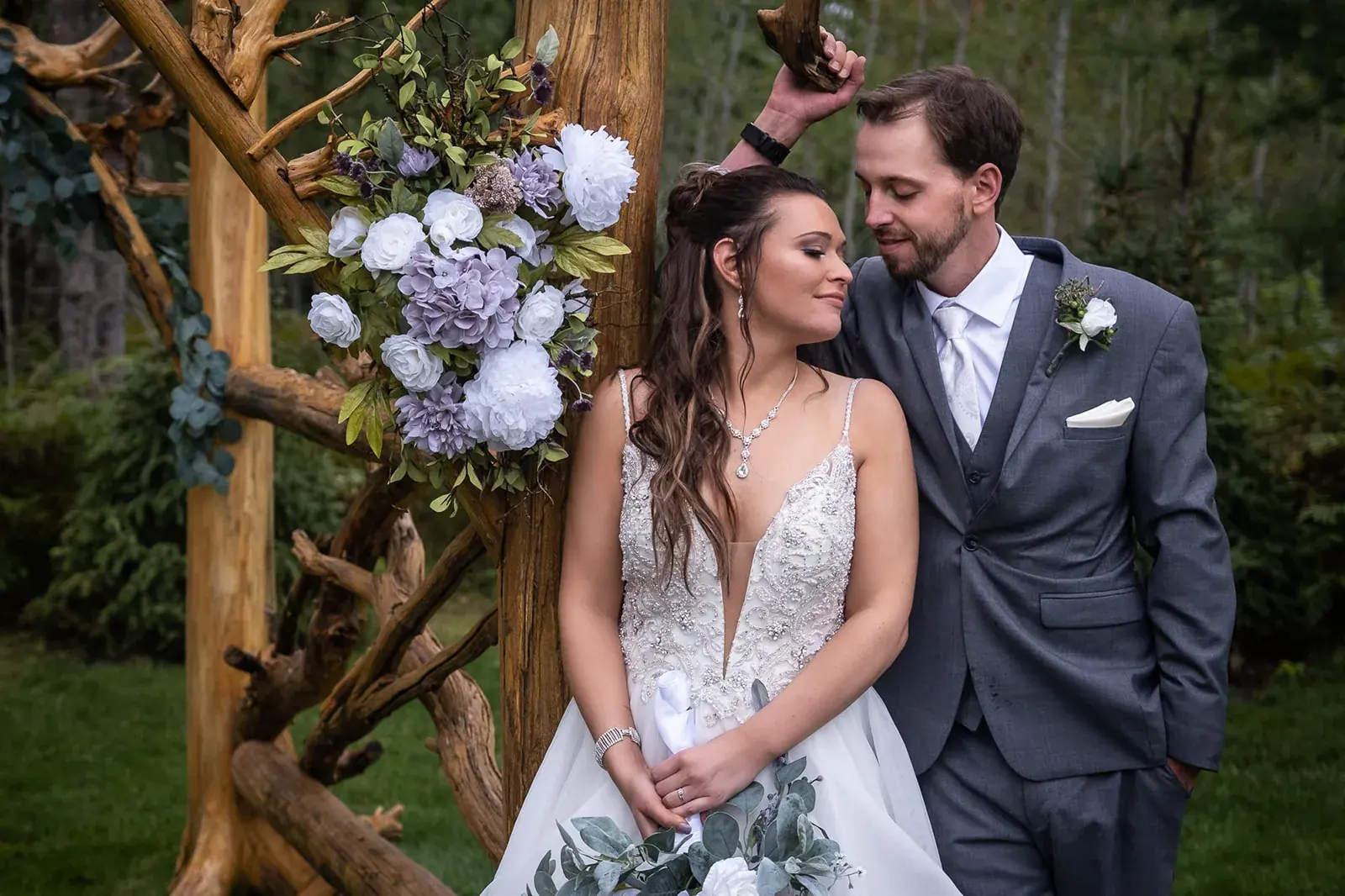 Bride and groom floral arbor smiling — Jessica & Joel's wedding at The Rut Hutt, Gaylord