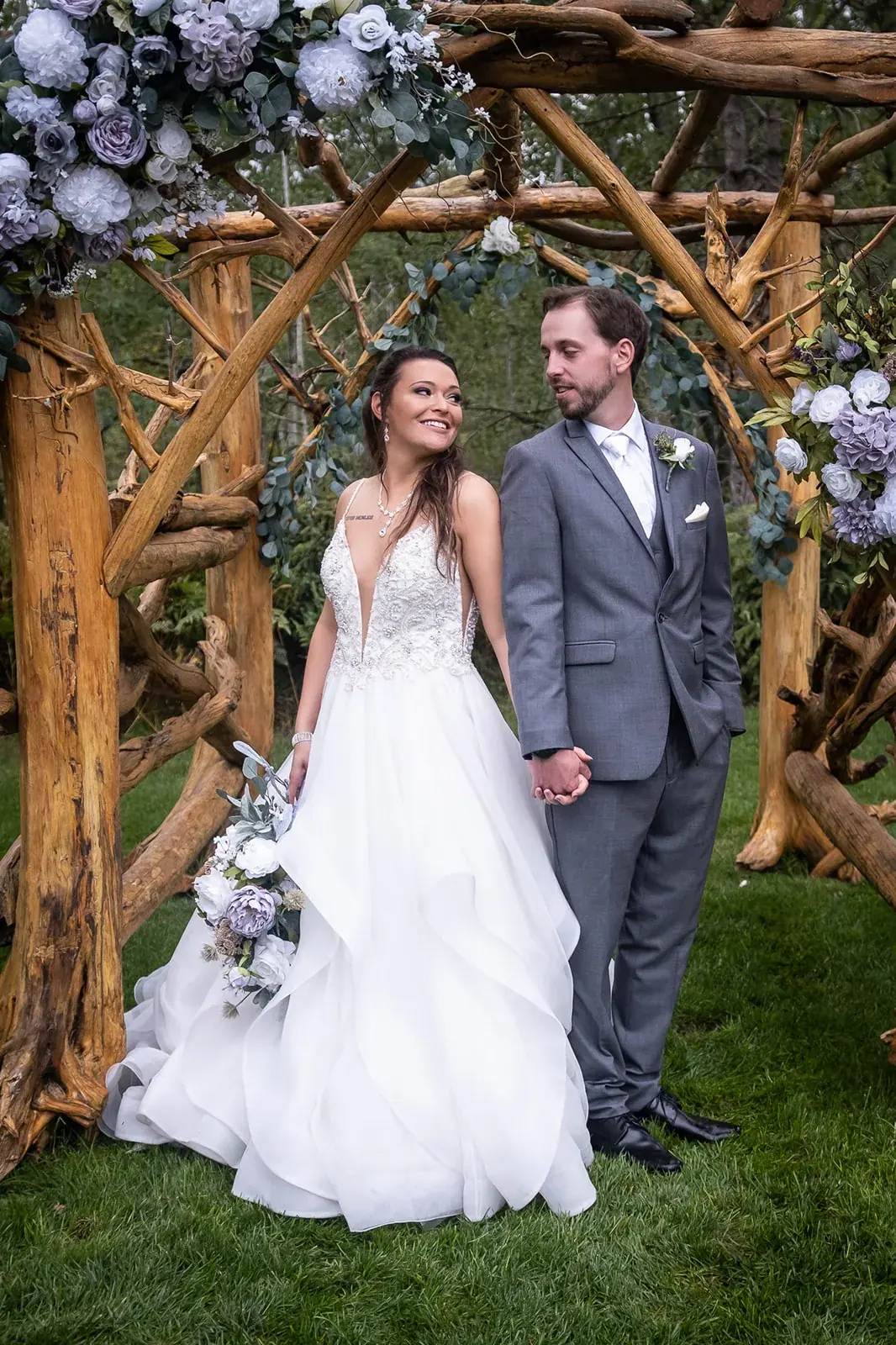 Bride and groom rustic floral arbor — Jessica & Joel's wedding at The Rut Hutt, Gaylord