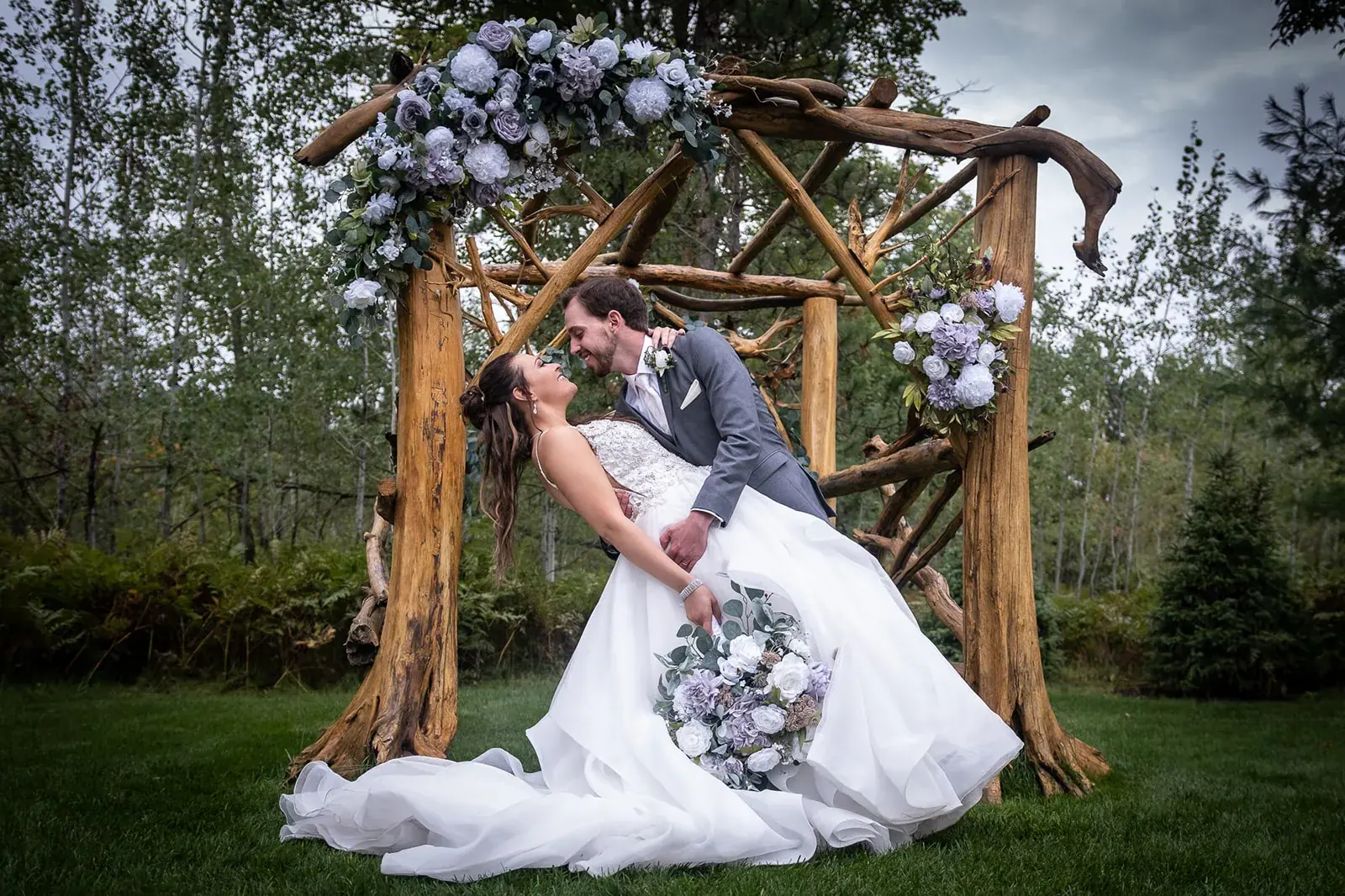 Groom dipping bride arbor — Jessica & Joel's wedding at The Rut Hutt, Gaylord