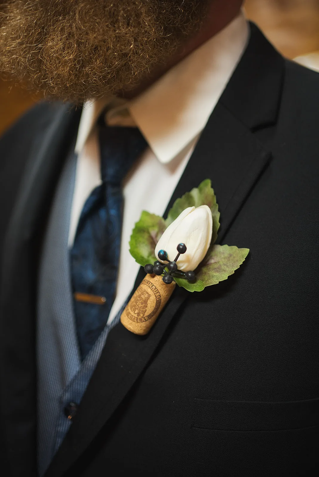 groom solo portrait leaning on large wine barrel