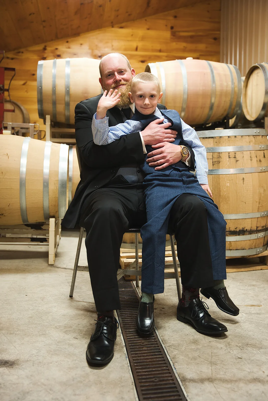 bw groom solo portrait leaning against large wine barrel