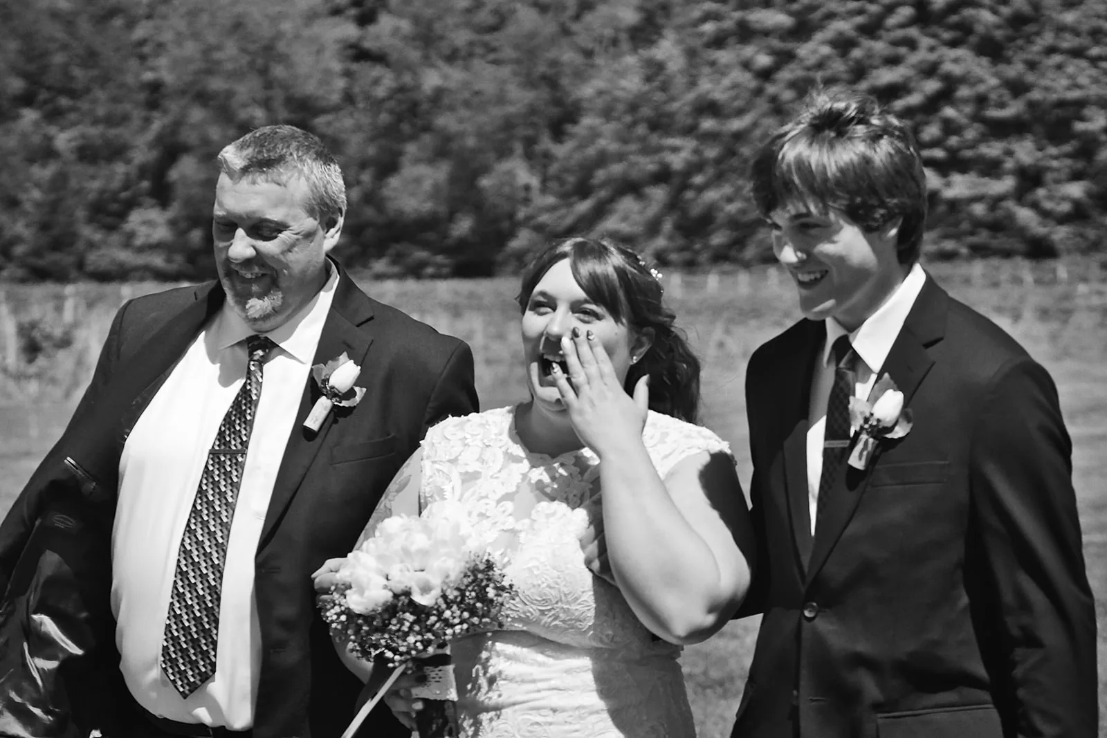 bw bride and groom kissing on brick path, wedding party watching