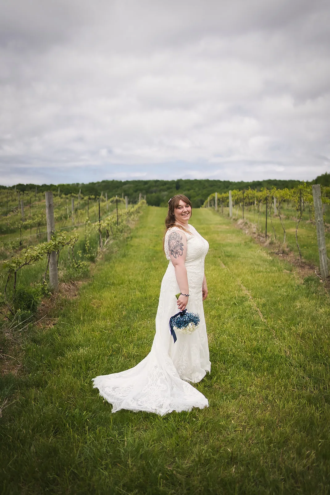 bride solo portrait walking through vineyard rows