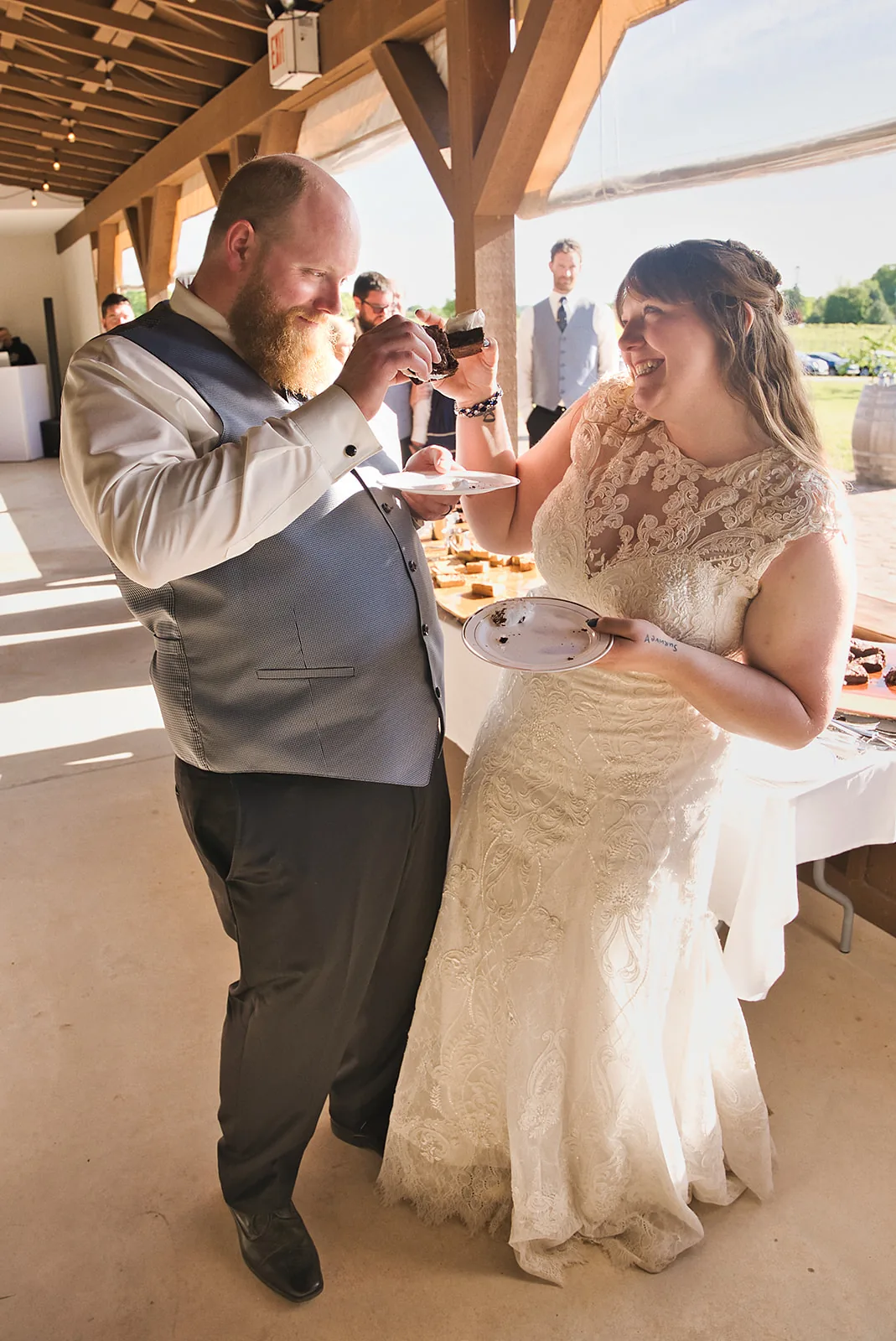 bride feeding groom cake at reception, candid