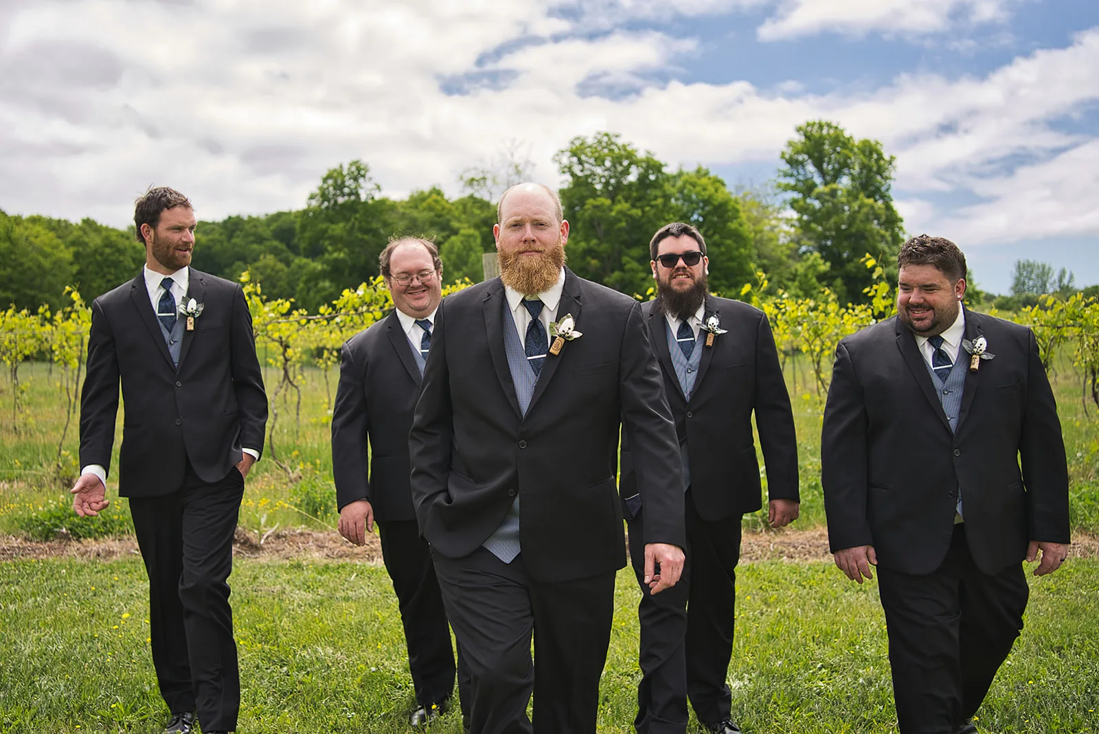bride kissing ring bearer boy forehead in vineyard field