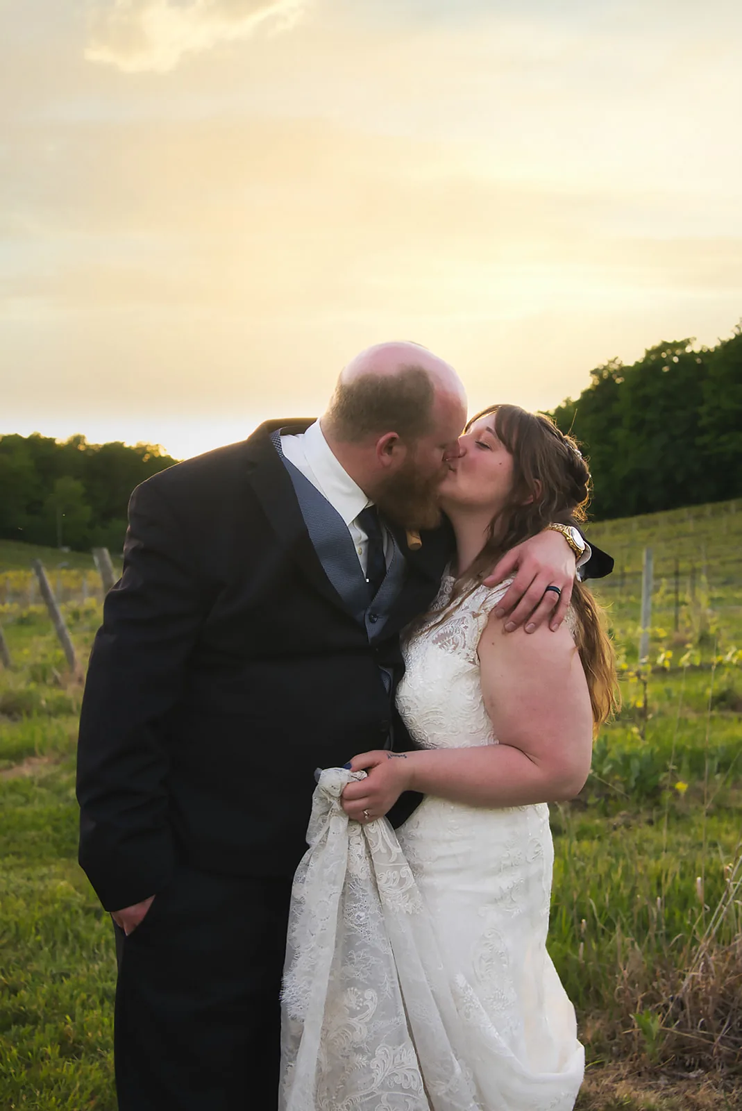 bride and groom seated portrait among wine barrels