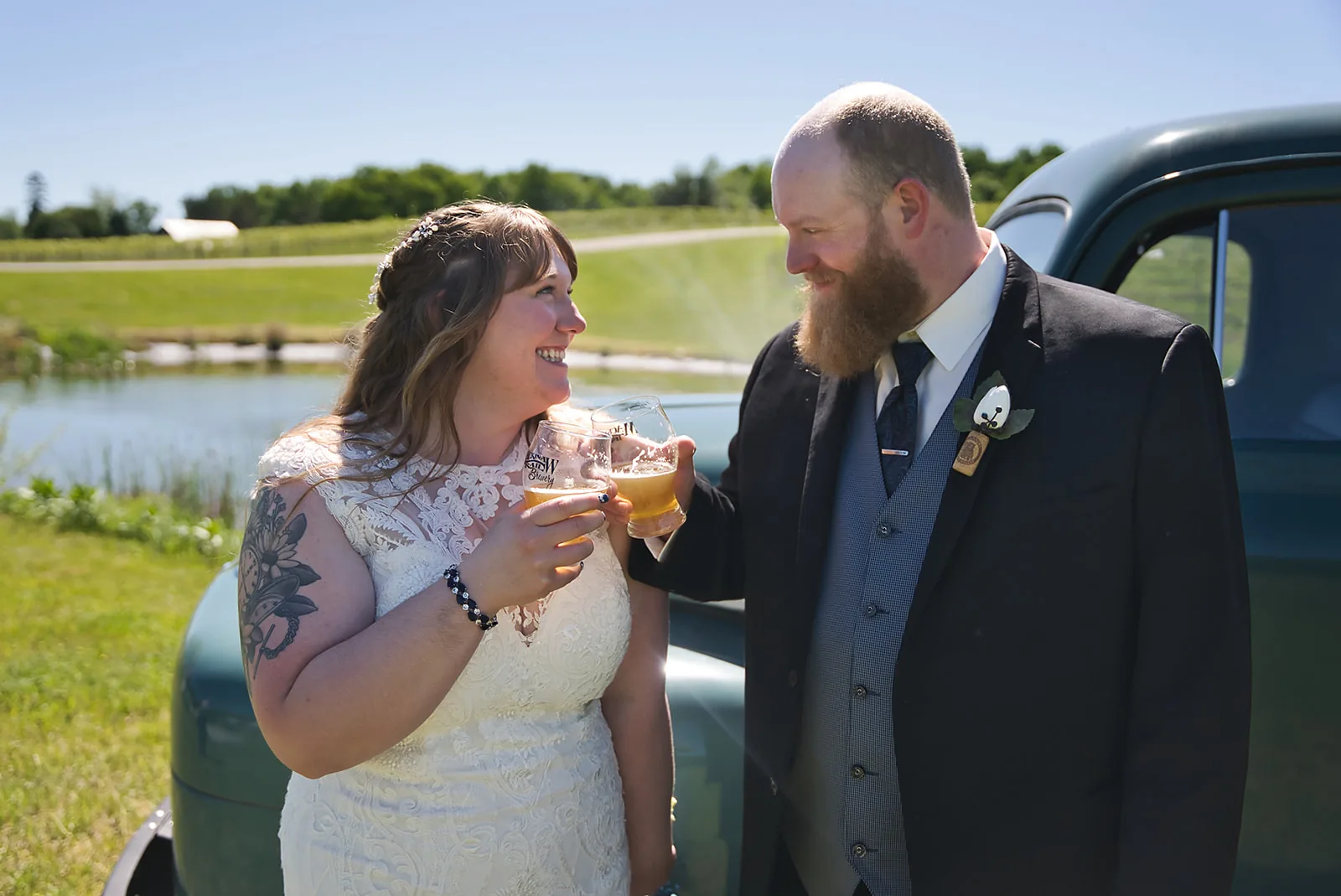 wide shot of ring bearer boy running toward bride in open field