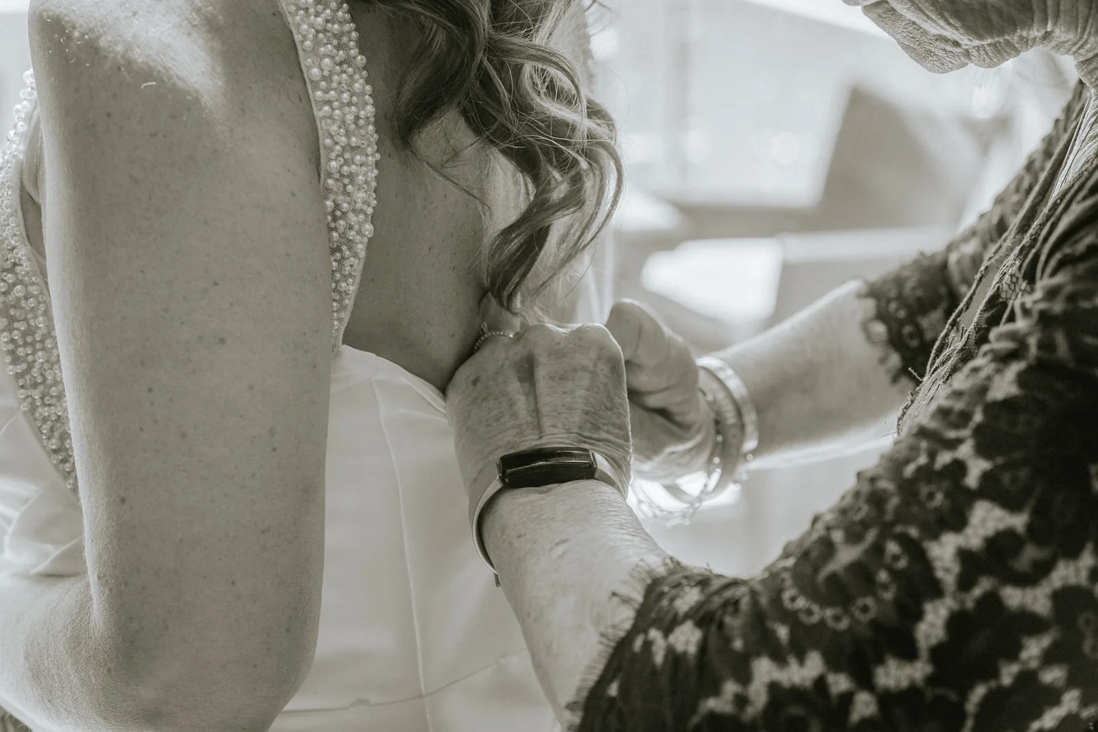 bw detail of bride hands adjusting lace sleeve