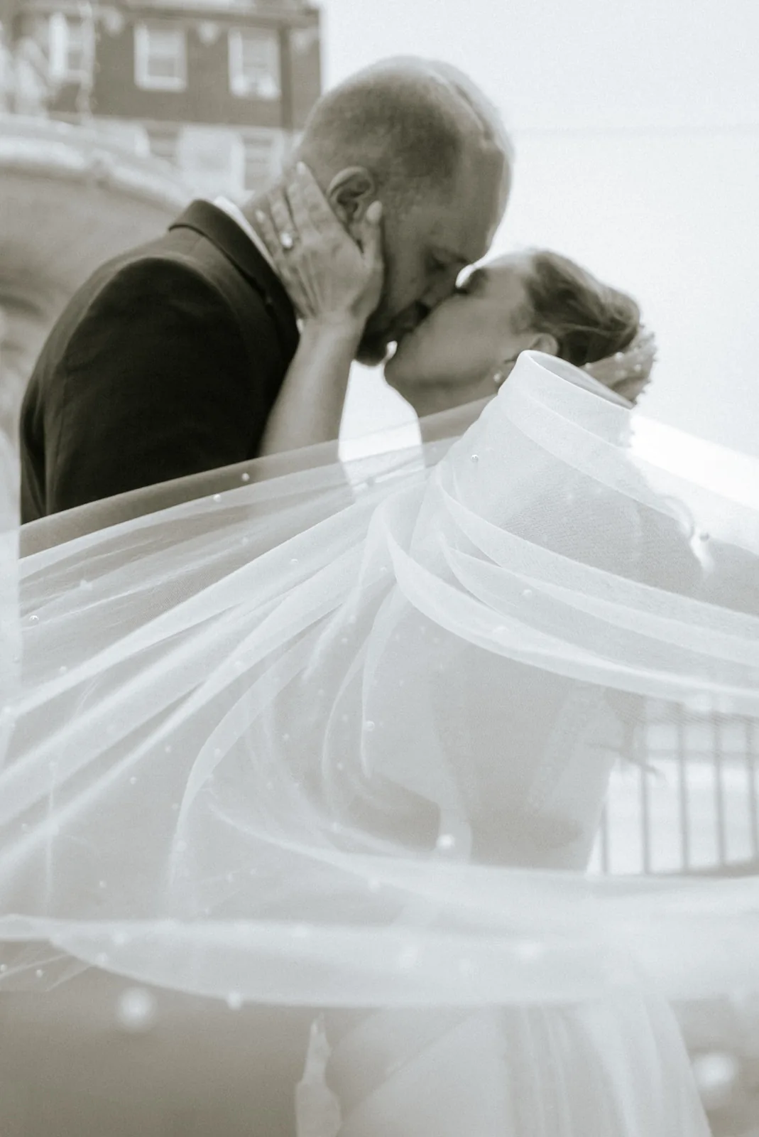 bw father and bride embracing, veil blowing, emotional first look